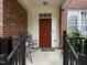 Inviting front porch with a red door, seating, and brick accents, offering a cozy welcome at 111 Finsbury Street St, Durham, NC 27703