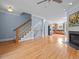 Spacious living room with hardwood floors, a fireplace, a staircase, and a view into the kitchen at 111 Finsbury Street St, Durham, NC 27703