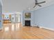 Open concept living room with a fireplace, hardwood floors, and a view of the adjacent kitchen at 111 Finsbury Street St, Durham, NC 27703