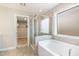 Bright bathroom features a glass shower, a soaking tub and entry to the walk-in closet at 111 Laporte Path, Garner, NC 27529