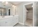 Bathroom with a double sink vanity, tiled shower and an open door to the walk-in closet at 111 Laporte Path, Garner, NC 27529