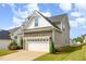 Side view of a two-story home featuring a stone-accented garage and well-maintained lawn at 111 Laporte Path, Garner, NC 27529