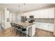 Contemporary kitchen with granite countertops, an island with bar seating, and white cabinets at 111 Laporte Path, Garner, NC 27529