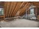 Unfinished attic features exposed rafters, ductwork, and a window at 1113 Smokewood Dr, Apex, NC 27502