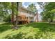 The back of the home features a wooden deck and a yard with trees and green grass at 1113 Smokewood Dr, Apex, NC 27502