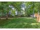 Fenced backyard with mature trees and lush lawn offering a private outdoor space at 1113 Smokewood Dr, Apex, NC 27502
