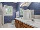 Bathroom featuring dual sinks, blue floral wallpaper, and a large mirror at 1113 Smokewood Dr, Apex, NC 27502
