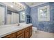 Bathroom featuring wood vanity, white countertop, and blue wallpaper at 1113 Smokewood Dr, Apex, NC 27502