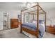 Bedroom features a wooden four-poster bed, and a door leading to a bathroom at 1113 Smokewood Dr, Apex, NC 27502