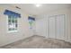 Bright bedroom features plush carpeting, two windows with blue valances, and double-door closets at 1113 Smokewood Dr, Apex, NC 27502