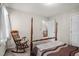 Bedroom with a four-poster bed, rocking chair, and view of stairs at 1113 Smokewood Dr, Apex, NC 27502