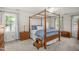 Bedroom features a wooden four-poster bed, a ceiling fan, and multiple windows at 1113 Smokewood Dr, Apex, NC 27502