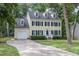 Traditional yellow home features blue shutters, attached garage, and a pristine lawn and driveway at 1113 Smokewood Dr, Apex, NC 27502