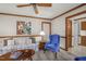 Cozy living room with ceiling fan, wood trim, floral couch, and blue chair at 1113 Smokewood Dr, Apex, NC 27502