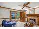 Bright living room featuring a brick fireplace, wood trim, and sliding door to a deck at 1113 Smokewood Dr, Apex, NC 27502