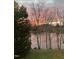 Tranquil backyard featuring bare trees and scenic lake views at dusk at 114 Fieldstone Dr, Burlington, NC 27215