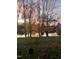 Picturesque backyard with lake views, mature trees, and colorful flowers at sunset at 114 Fieldstone Dr, Burlington, NC 27215