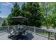 Outdoor deck with a dining table, umbrella and lovely backyard at 114 Fieldstone Dr, Burlington, NC 27215
