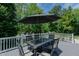 Outdoor deck with a dining table, umbrella and lovely backyard at 114 Fieldstone Dr, Burlington, NC 27215
