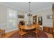 The dining room features an oval table and chairs, complemented by natural light from a large window with plantation shutters at 114 Fieldstone Dr, Burlington, NC 27215