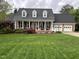 Charming brick home featuring a well-manicured lawn, a two-car garage and a welcoming covered front porch at 114 Fieldstone Dr, Burlington, NC 27215