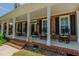 Charming front porch with rocking chairs and brick columns creating a welcoming entryway at 114 Fieldstone Dr, Burlington, NC 27215