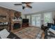 Cozy living room featuring a brick fireplace, hardwood floors, and ample natural light through large windows at 114 Fieldstone Dr, Burlington, NC 27215
