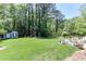 Green backyard with a patio set and a swing set among mature trees at 1206 Ivy Ln, Raleigh, NC 27609