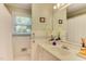Bright bathroom features a single vanity, large mirror, and striped wallpaper at 1206 Ivy Ln, Raleigh, NC 27609