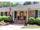 Welcoming front porch with a bright red door, lush greenery, and charming potted plants at 1206 Ivy Ln, Raleigh, NC 27609