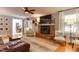Bright living room showcasing hardwood floors, a brick fireplace, and a seamless flow to other living spaces at 1206 Ivy Ln, Raleigh, NC 27609