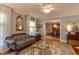 Relaxing living room with sofa and mirror decor with a view into the dining room at 1206 Ivy Ln, Raleigh, NC 27609