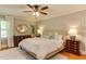 Bright main bedroom featuring a ceiling fan, neutral walls, and carpet flooring at 1206 Ivy Ln, Raleigh, NC 27609