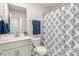 Well-lit bathroom with a single sink vanity, toilet, and a shower with a decorative shower curtain at 1230 Adrian Ct, Mebane, NC 27302