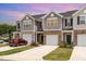 Townhome exterior with neutral siding, brick accents, individual driveways, and attached garages at 1230 Adrian Ct, Mebane, NC 27302
