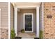Close-up of front door with black door, brick and siding accents, and house number 1230 at 1230 Adrian Ct, Mebane, NC 27302
