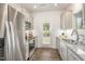 Modern kitchen with stainless steel appliances, white cabinetry, granite countertops, and backyard access at 1230 Adrian Ct, Mebane, NC 27302