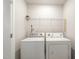 Functional laundry room featuring a washer, dryer, and a shelf for storage solutions at 1230 Adrian Ct, Mebane, NC 27302