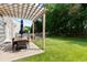 Charming backyard patio with pergola, outdoor dining set, and a cozy fire pit for relaxing evenings at 12417 Kendall Ridge Ct, Durham, NC 27703
