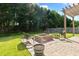 Inviting brick patio with fire pit, seating, and lush green lawn for outdoor enjoyment and entertaining at 12417 Kendall Ridge Ct, Durham, NC 27703