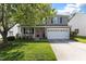 Charming two-story home with a well-manicured lawn, mature tree, and a welcoming front porch at 12417 Kendall Ridge Ct, Durham, NC 27703