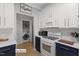 Modern kitchen featuring two-tone cabinets, subway tile backsplash, and adjacent laundry room at 12417 Kendall Ridge Ct, Durham, NC 27703