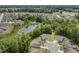 Aerial community view with homes nestled among lush green trees and a serene pond at 1304 Essex Skipper Way, Fuquay Varina, NC 27526