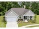 Aerial view of a charming single-Gathering home with a well-manicured front yard and attached two-car garage at 1304 Essex Skipper Way, Fuquay Varina, NC 27526