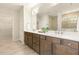 Bright bathroom featuring a double vanity with large mirror and a tiled shower at 1304 Essex Skipper Way, Fuquay Varina, NC 27526