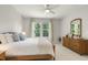 Sunlit bedroom with a ceiling fan, dresser, and bedside table at 1304 Essex Skipper Way, Fuquay Varina, NC 27526