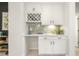 Charming butler's pantry with a wine rack, sage backsplash and white cabinets at 1304 Essex Skipper Way, Fuquay Varina, NC 27526