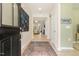 Inviting entryway with wood floors, decorative rug, art, and a view into the living space with a fireplace at 1304 Essex Skipper Way, Fuquay Varina, NC 27526