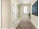 Bright hallway features wood-look floors, neutral walls, and a decorative rug with a large piece of art at 1304 Essex Skipper Way, Fuquay Varina, NC 27526