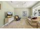 Comfortable living room featuring a neutral color scheme, a TV, and a large window for natural light at 1304 Essex Skipper Way, Fuquay Varina, NC 27526